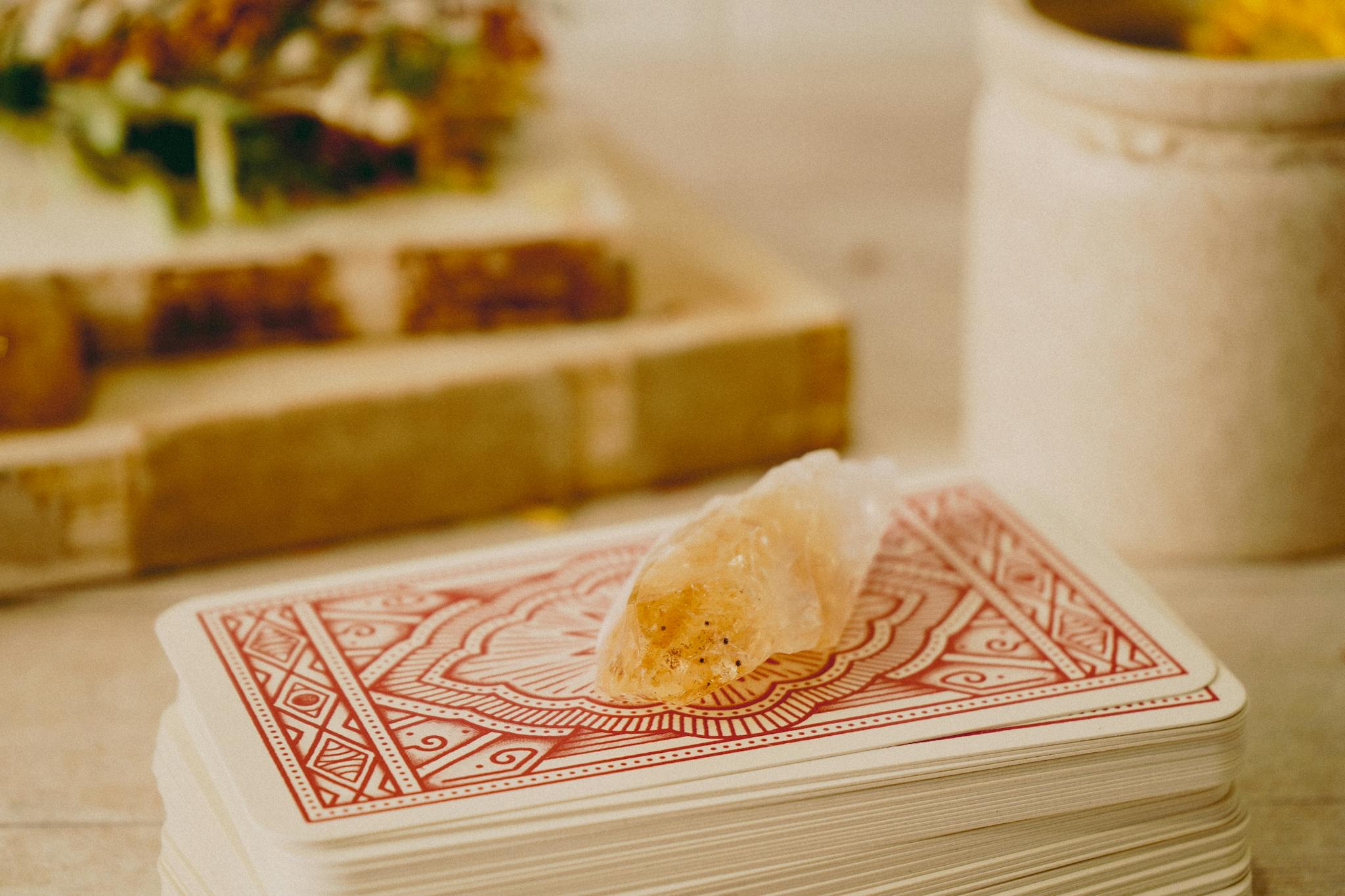 A mystical crystal placed on ornate tarot cards, suggesting a scene of fortune telling.