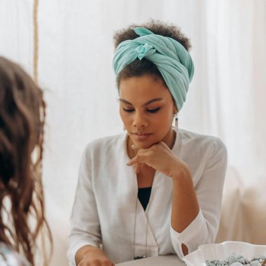 A woman in a headscarf focuses intently during a spiritual reading session.