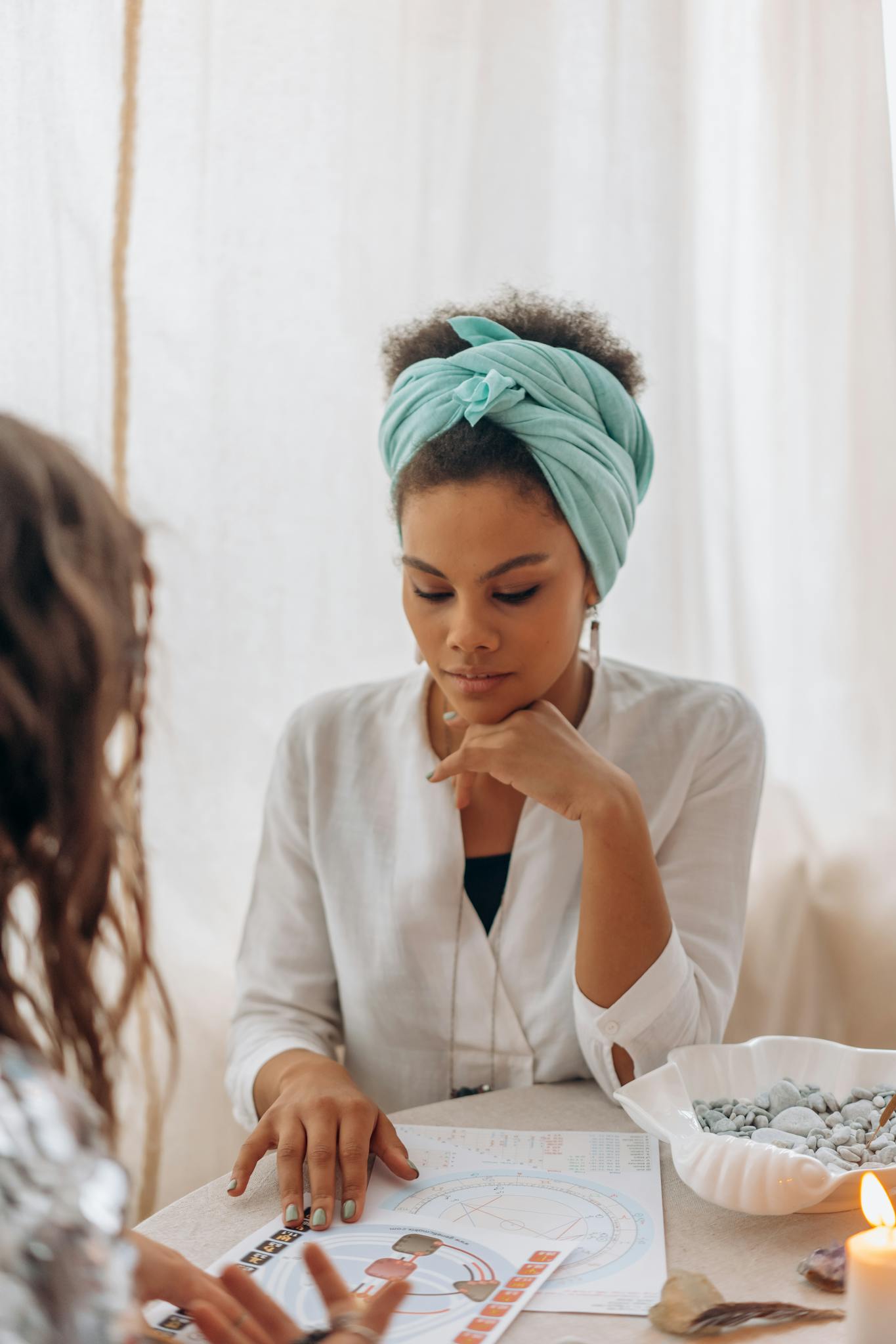 A woman in a headscarf focuses intently during a spiritual reading session.