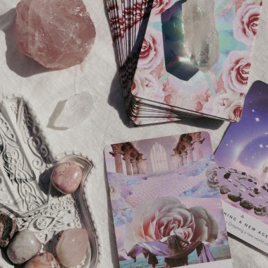 Tarot and crystals on a soft white background for spiritual guidance and healing.